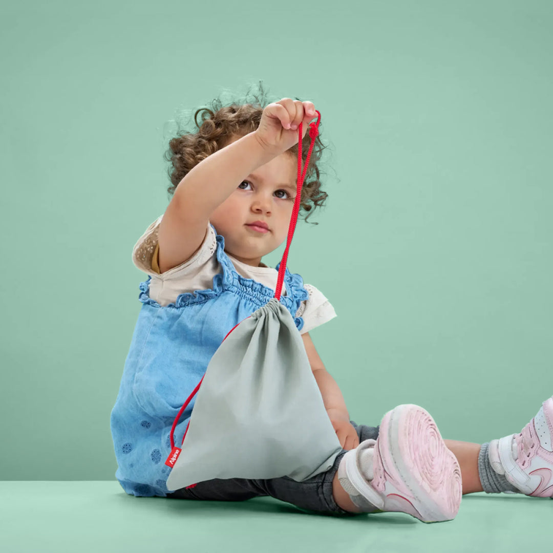Toddler holding Alpine Muffy Baby storage bag