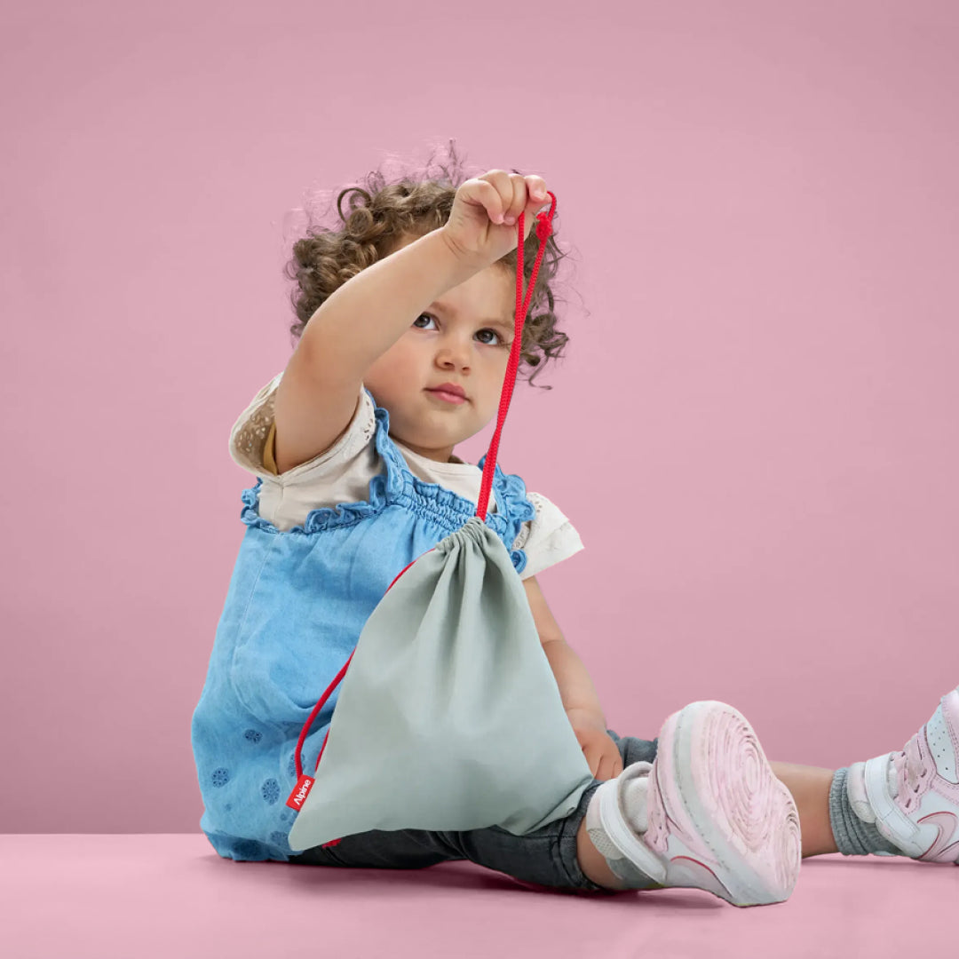 Toddler holding Alpine Muffy Baby storage bag