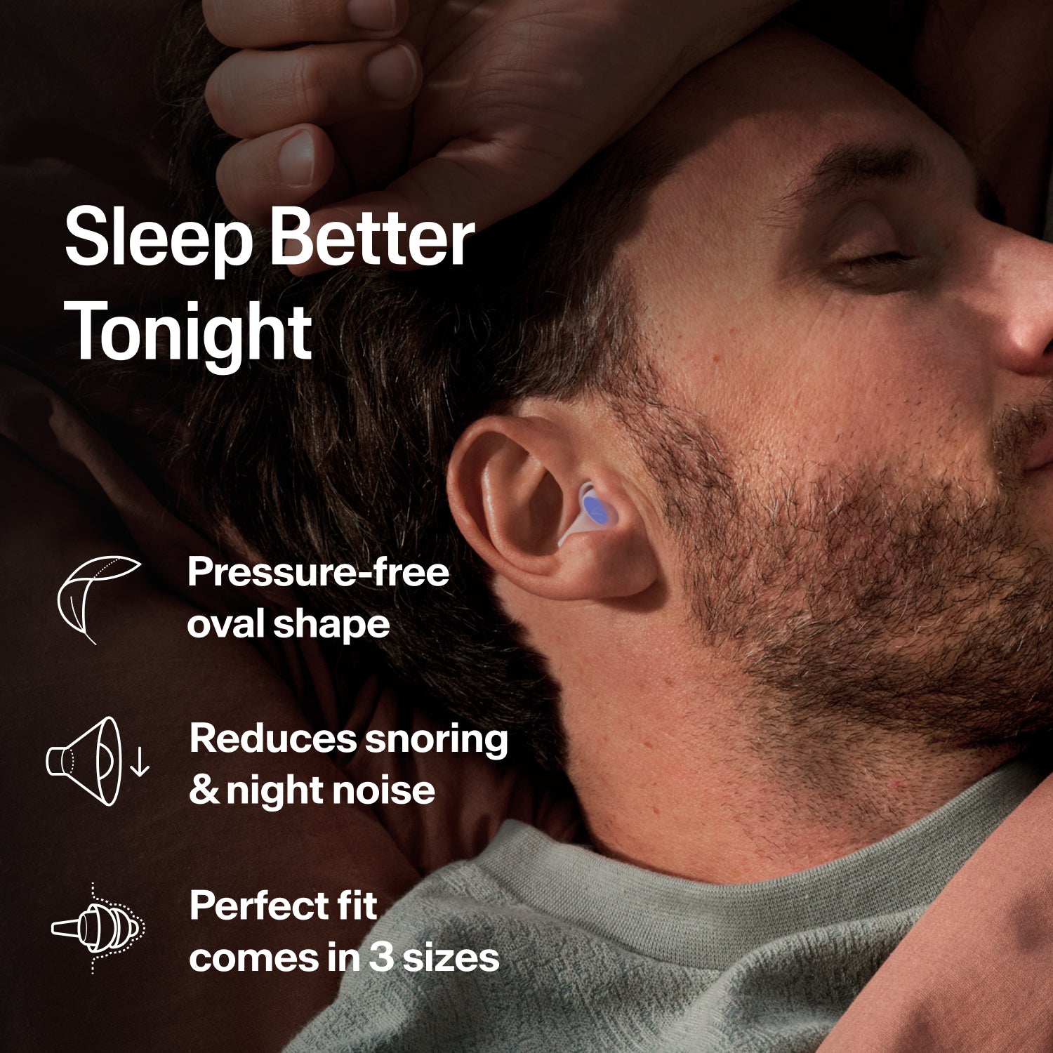 Man asleep on his side wearing an Alpine SleepDeep Multisize earplug to block snoring and night noise