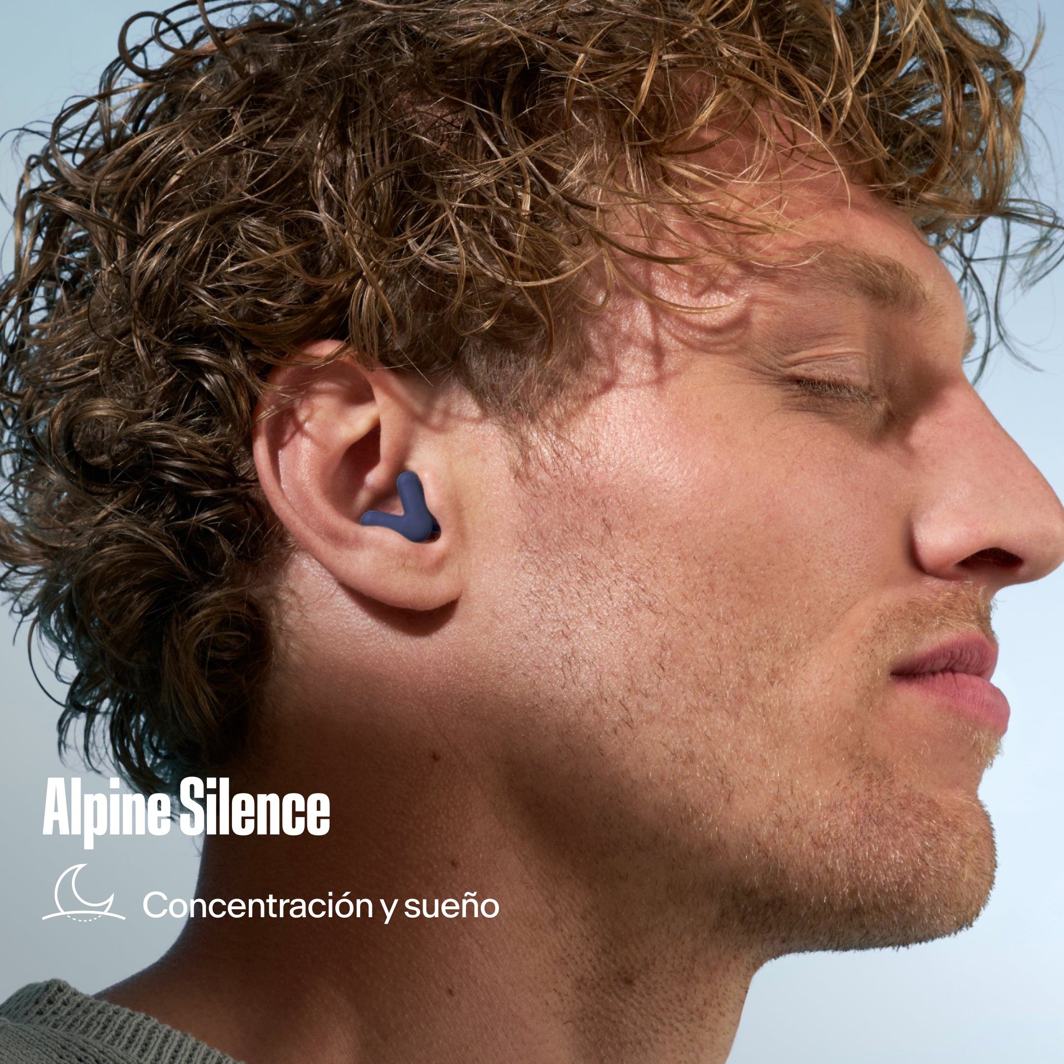 Tapón para los oídos Alpine Silence en la oreja de un hombre con el pelo rizado, con el texto &