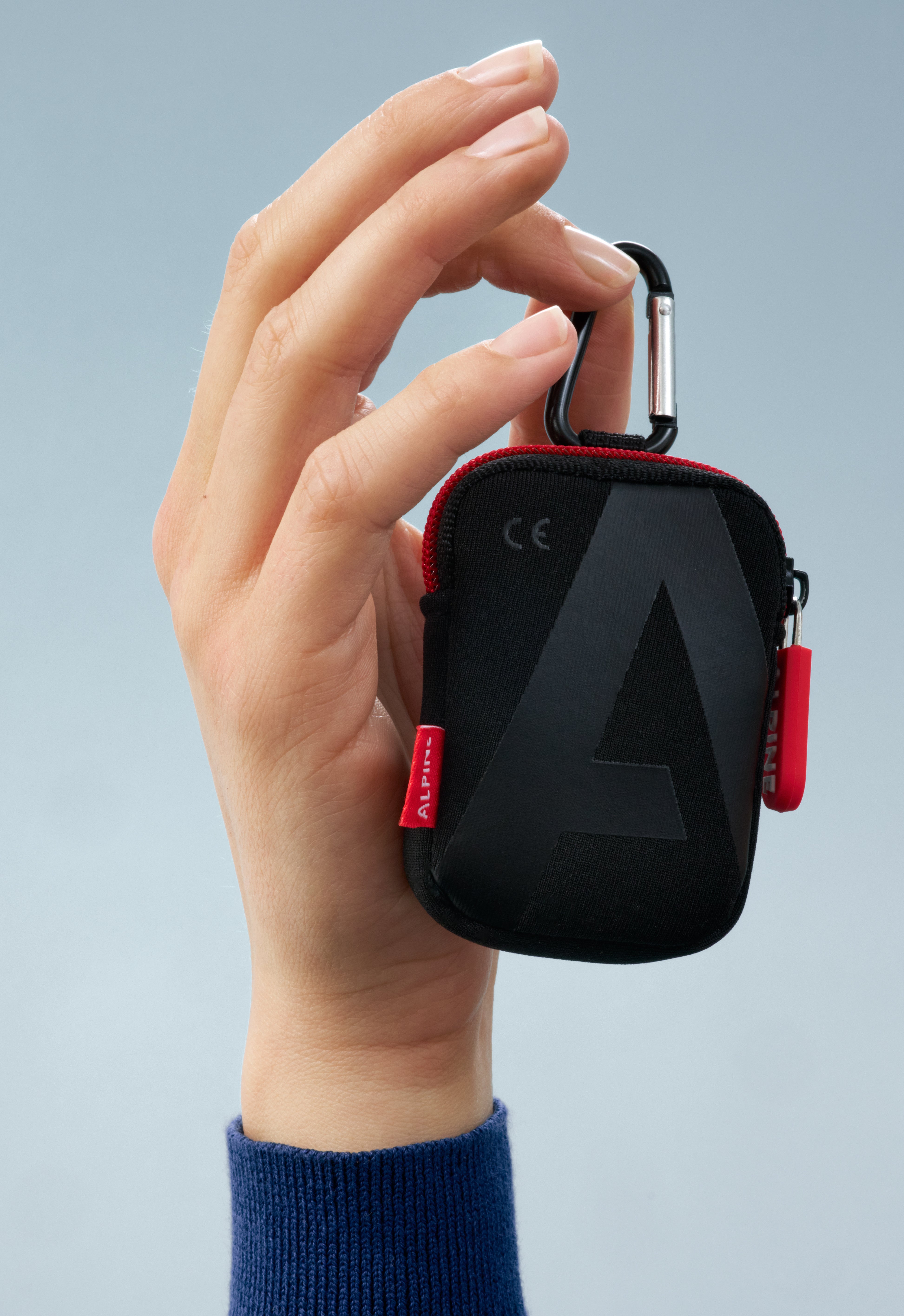 Alpine Pouch Deluxe held by its carabiner in a hand