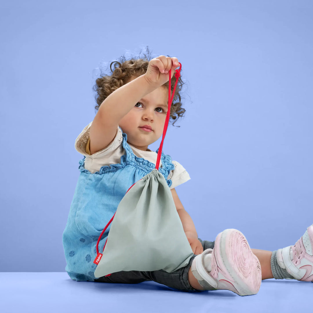 Toddler holding Alpine Muffy Baby storage bag 