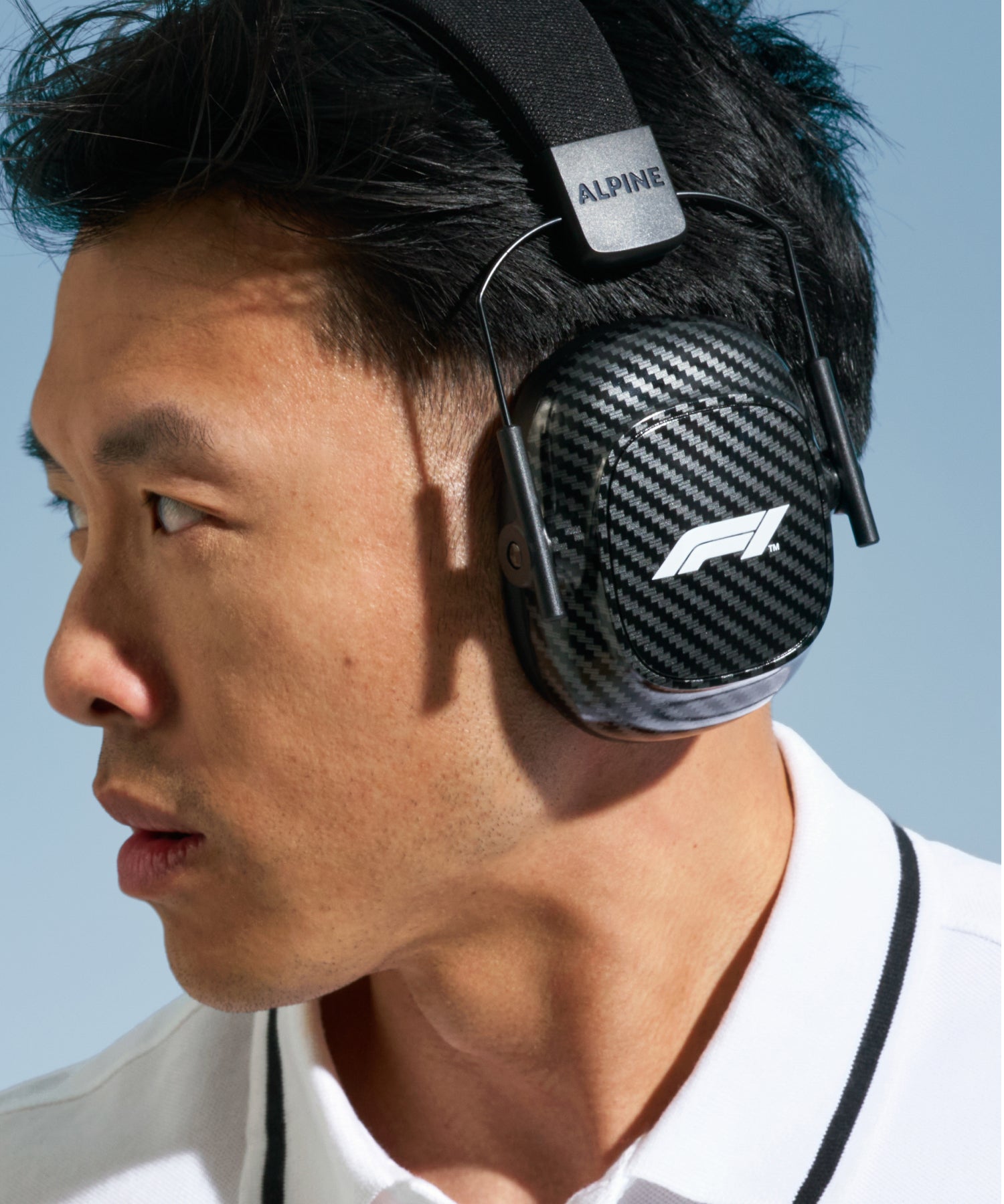 Man with dark hair in a white polo shirt wearing Alpine Formula 1® Earmuffs, side profile 